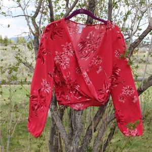 Pink floral top with a cross front and elastic bottom.